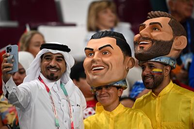A football fan with supporters wearing masks of Portugal's Cristiano Ronaldo and Argentina's Lionel Messi in Doha on December 17. AFP