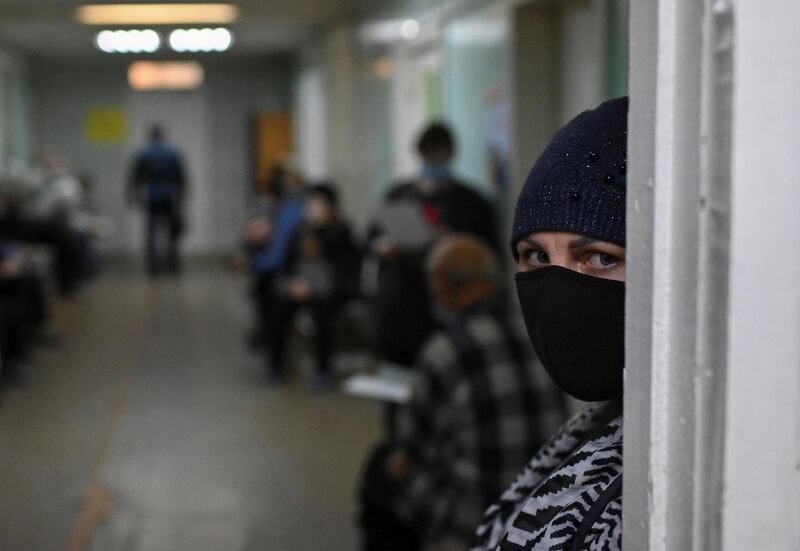 A patient wearing a protective face mask waits in a queue outside a medical room at a local clinic in Omsk, Russia. Reuters