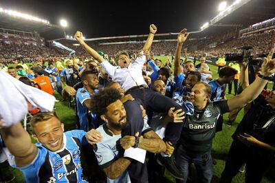 In this Wednesday, Nov. 29, 2017 photo, Brazil's Gremio soccer players carry their coach Renato Gaucho after clenching the Copa Libertadores championship following their victory over Argentina's Lanus in Buenos Aires, Argentina. (AP Photo/Esteban Felix)