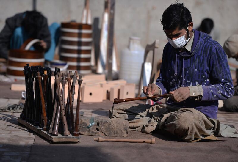 A Pakistani worker polishes a component to be used to make a set of bagpipes at the Mid East bagpipe factory. AFP.