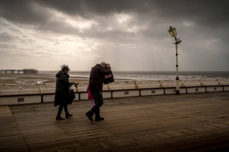 People brave wind and rain on Blackpool's North Pier as heavy clouds in the west mark the approach of Storm Kathleen to the UK. Getty Images