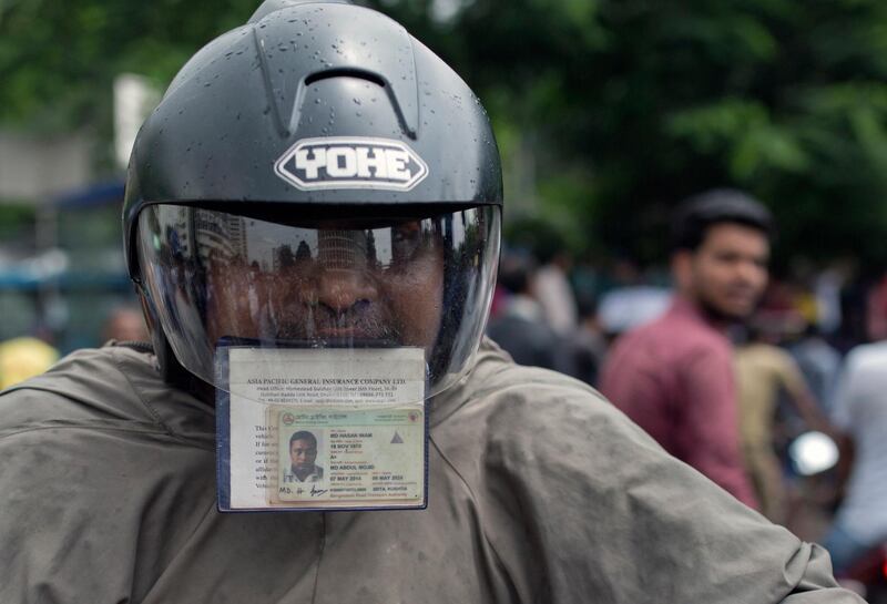 A Bangladeshi motorcyclist holds his driving license and registration papers in his mouth as protesting students check vehicle registrations and drivers licenses during a rally demanding safe roads on the seventh consecutive day of protests, in Dhaka city, Bangladesh.  EPA / MONIRUL ALAM