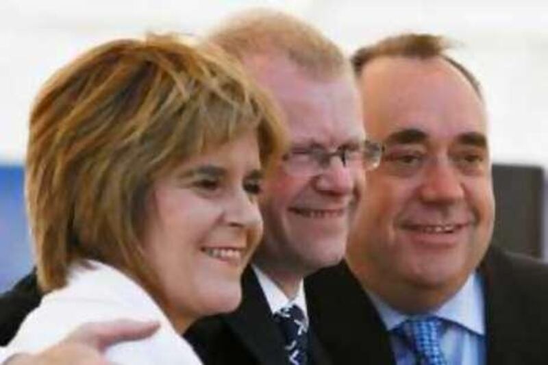 Newly elected Scottish National Party MP for the Glasgow east constituency John Mason (C) poses for photographs with his deputy leader Nicola Sturgeon (L) and leader Alex Salmond after a post election press conference at the Fort retail park in Glasgow July 25, 2008.  REUTERS/David Moir (BRITAIN) *** Local Caption ***  GLA345_BRITAIN_0725_11.JPG