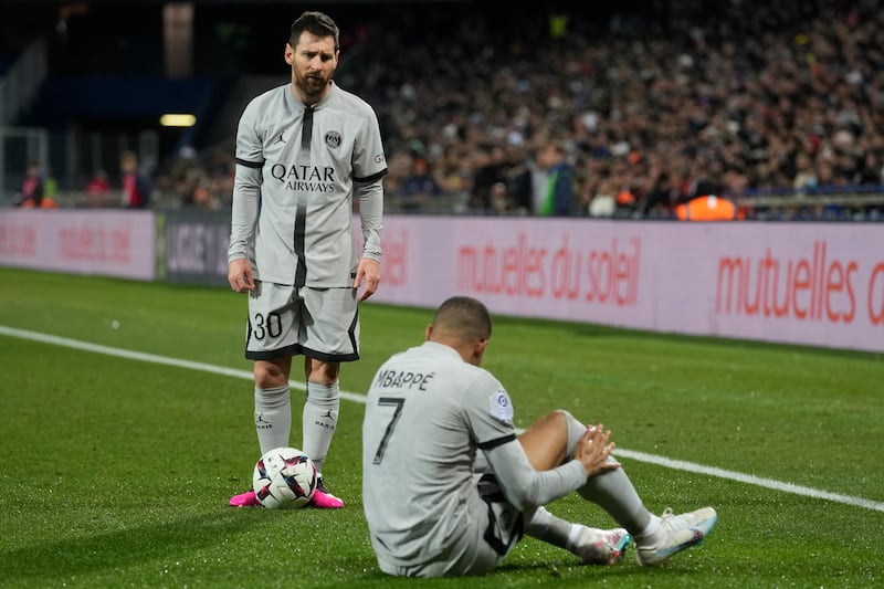 PSG's Lionel Messi stands next to injured teammate Kylian Mbappe. AP Photo 