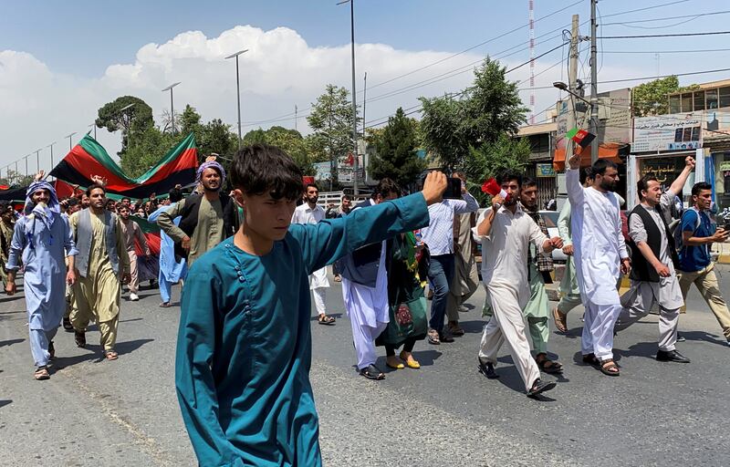 People carrying the national flag march in Kabul. Reuters