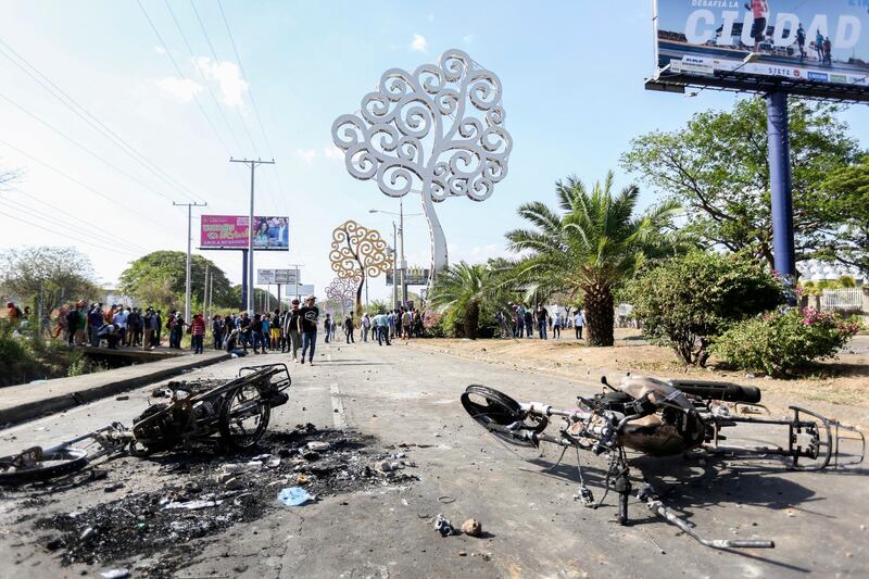 The charred remains of motorcycles belonging to government supporters and set on fire by protesters sit on a main avenue during a third day of violent clashes in Managua, Nicaragua. Alfredo Zuniga / AP Photo