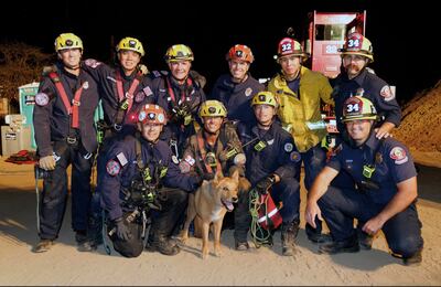 Firefighters take a photograph with Cesar after rescuing the 13-year-old blind dog. Pasadena Fire Department / AP