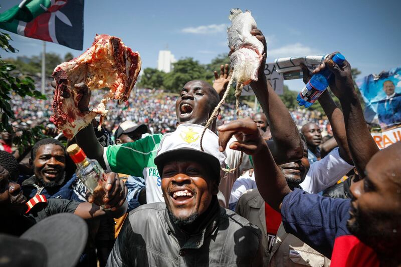 epa06485807 A supporter of the Kenyan opposition National Super Alliance (NASA) and its leader Raila Odinga holds up a piece of meat and fish during Odinga's 'swearing-in' ceremony in Nairobi, Kenya, 30 January 2018. Odinga was 'sworn-in' as an alternative President of Kenya despite the warning by the government of Uhuru Kenyatta who won the disputed repeat Presidential election that such an act can amount to a treason. The ceremony attended by thousands of supporters was carried out peacefully with very almost no police presence.  EPA/DAI KUROKAWA