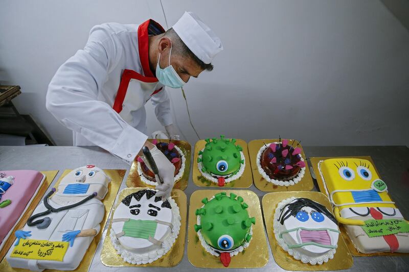 A Palestinian baker puts the final touches on coronavirus-themed cakes at his bakery in Khan Yunis in the southern Gaza Strip.   AFP