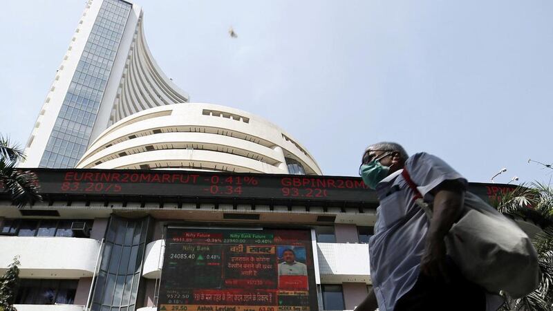 A man walks past the Bombay Stock Exchange. Economists have cut India’s growth projections from already historic lows as the virus continues to spread. Reuters