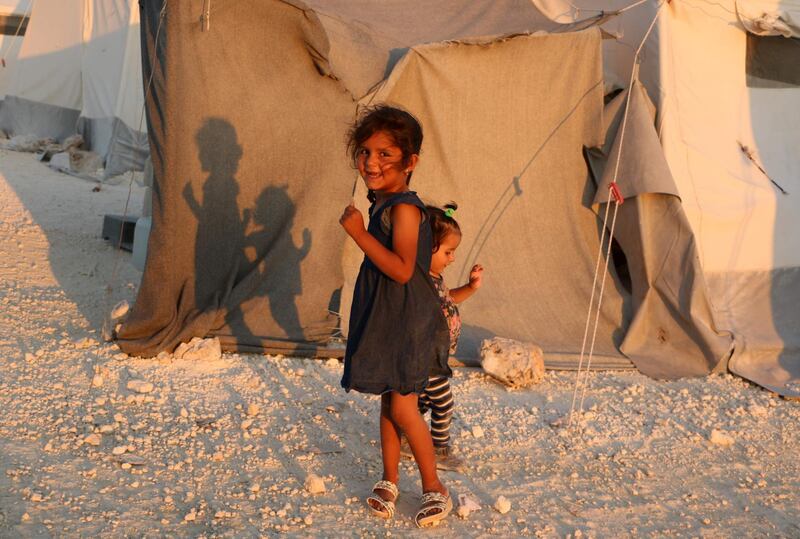 Displaced Syrian girls stand next to a tent provided by a Turkish humanitarian organisation at a camp for displaced people in the northern Idlib province. AFP