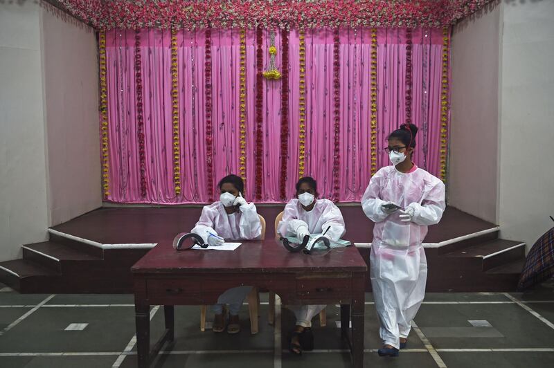 Medical volunteers wait to register people for coronavirus tests at a marriage hall temporarily converted into a testing centre, in Mumbai on July 17, 2020. AFP