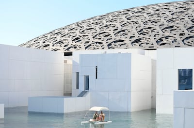 Visitors enjoy a catamaran ride around Louvre Abu Dhabi.  Khushnum Bhandari / The National
