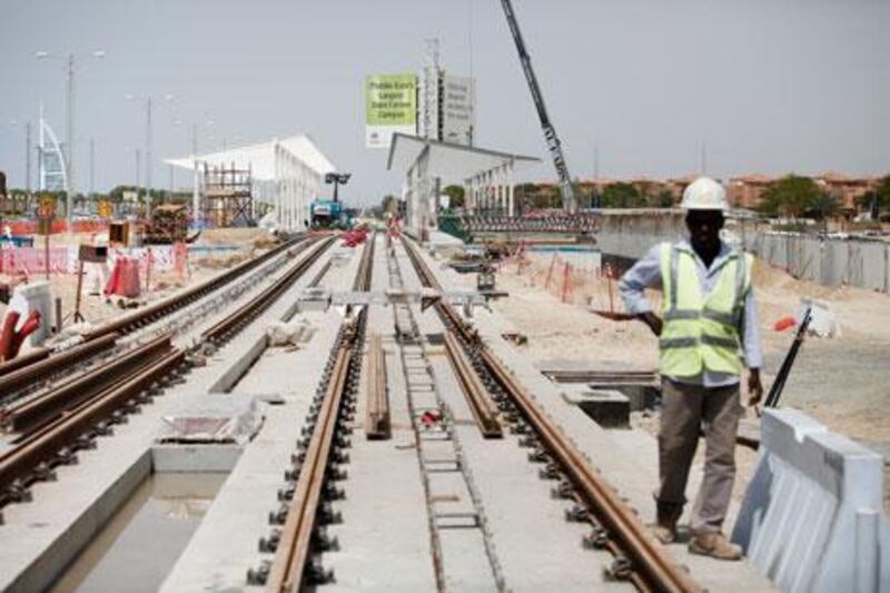 Workers lay tracks and build a station near Dubai Media City for the project. The trams are being manufactured in France.