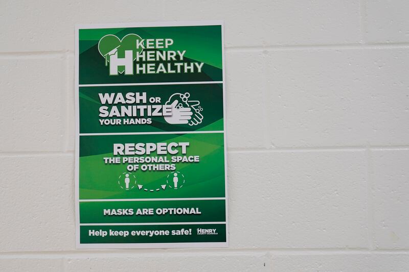 A sign hanging in the hallway reads "Keep Henry Healthy, wash or sanitize your hands, repeat the personal space of others and masks are optional" at Tussahaw Elementary school on August 4, 2021, in McDonough, Georgia, US. AP