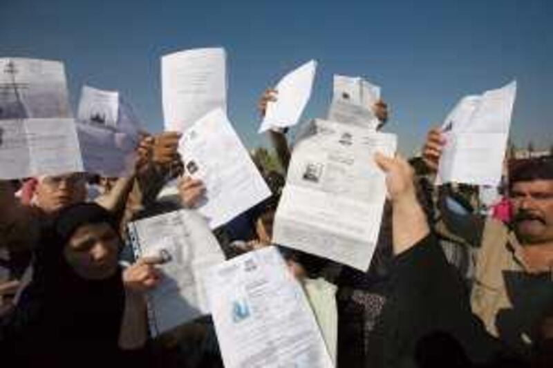 Iraqi refugees hold up their registration certificates at a protest outside the United Nations refugee agency's head offices in Damascus, Syria, Tuesday 26 May 2009. Hundreds of thousands of Iraqis continue to live in exile in conditions the UNHCR describes as "desperate".