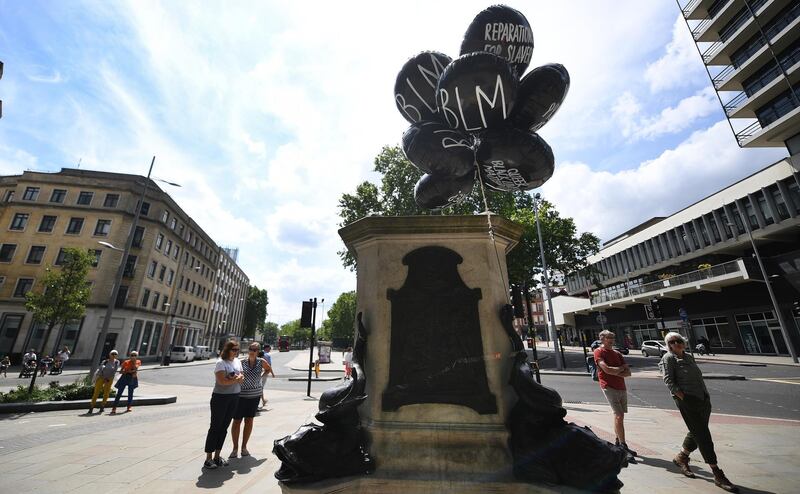 People look over the plinth of the Edward Colston statue in Bristol, Britain.  EPA