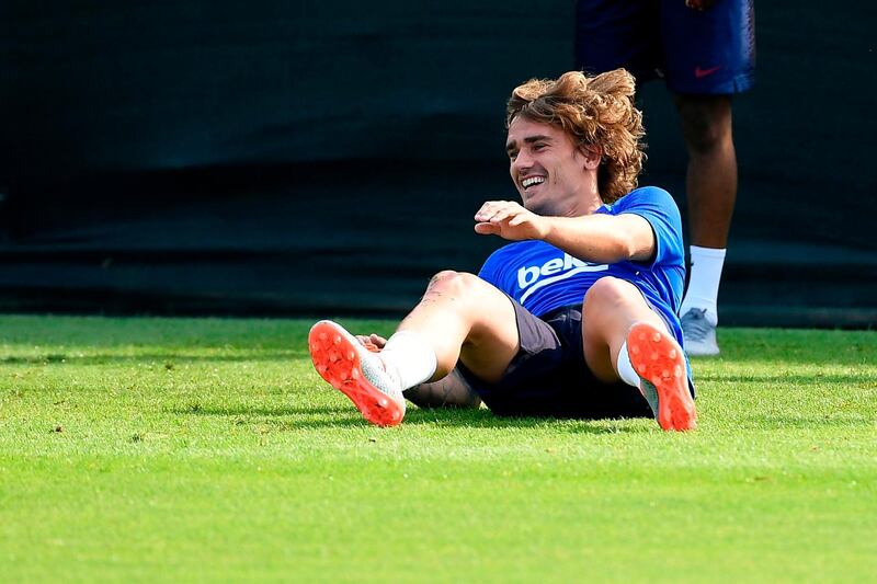 Barcelona's French forward Antoine Griezmann laughs as he falls during training. AFP