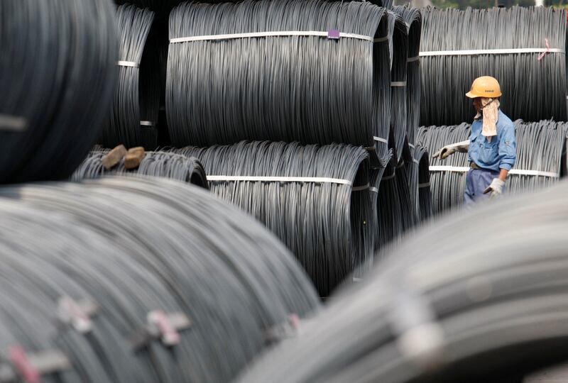 A worker checks steel coils at facility in Tokyo. Japanese manufacturers are feeling the pain of soaring prices of steel and other materials. Reuters