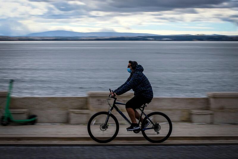 A man rides a bicycle in a quiet Lisbon, Portugal. Portugal will start to ease restrictions due to a decrease in coronavirus cases. AFP