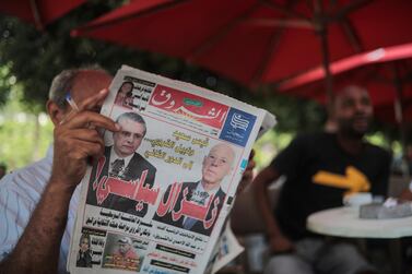 A man reads a newspaper showing candidates Kais Saied and Nabil Karoui on its front-page, a day after the first round of presidential elections in Tunis. AP Photo