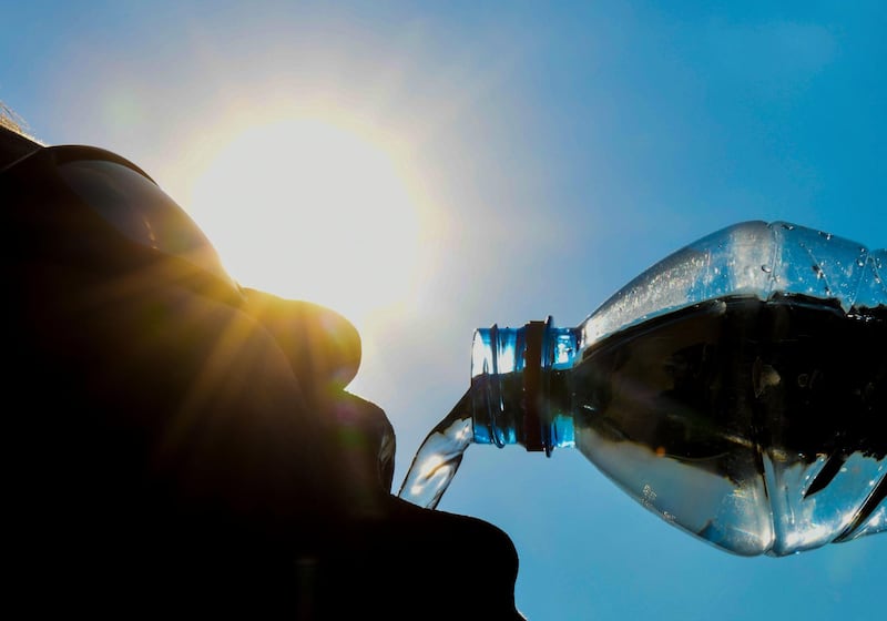A man poses while drinking from a water bottle as the sun shines in the northern French city of Lille on July 25, 2018.

 Some 18 departments across France have been placed on an 'orange' alert as heatwave conditions prevail across western Europe. / AFP / DENIS CHARLET
