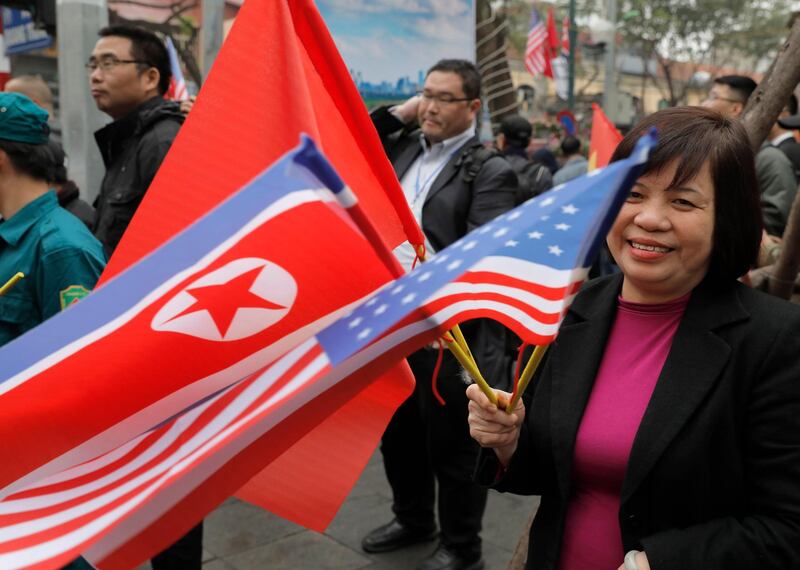 A woman waves flags of the US, North Korea and Vietnam outside the Melia Hotel. AP Photo
