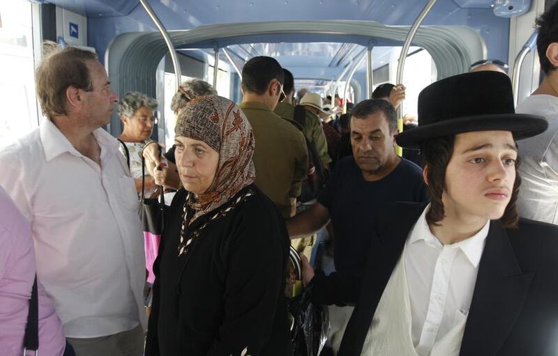 Israelis and Palestinians from East Jerusalem ride the new-light rail system through the holy city.  AFP Photo/Ahmad Gharabli