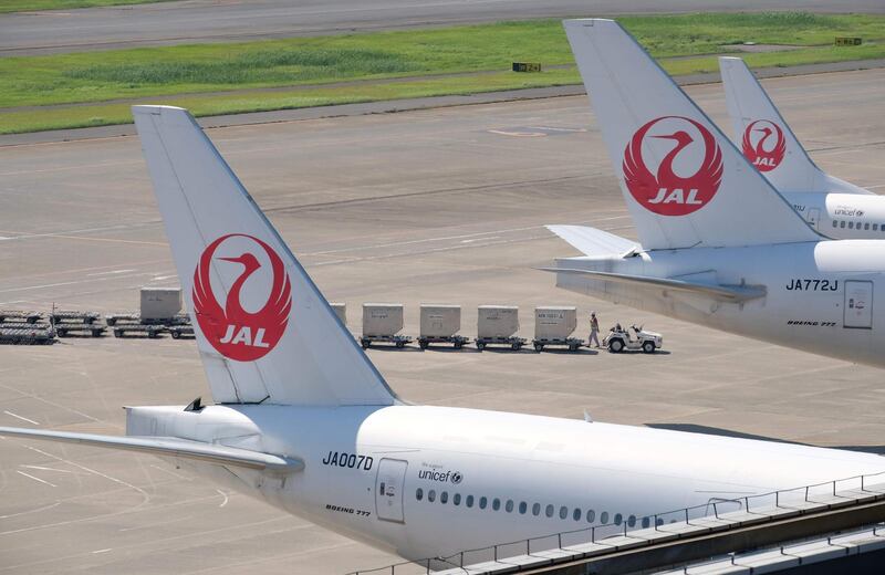 An airport employee works under passenger planes of Japan Airlines at Tokyo's Haneda airport on July 31, 2018. 
Major Japanese carriers All Nippon Airways (ANA) and Japan Airlines (JAL) on July 31 reported sluggish April-June profits as fuel costs weighed despite higher revenues.  / AFP PHOTO / Kazuhiro NOGI