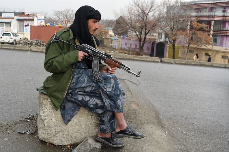 A Taliban fighter sits at a checkpoint in Kabul. The militant group took control of Afghanistan in August. AFP