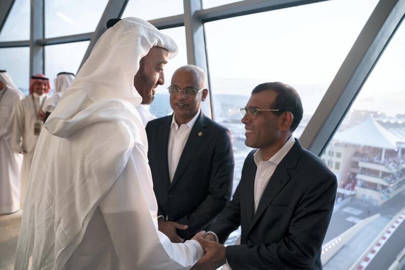 YAS ISLAND, ABU DHABI, UNITED ARAB EMIRATES - December 01, 2019: HH Sheikh Mohamed bin Zayed Al Nahyan, Crown Prince of Abu Dhabi and Deputy Supreme Commander of the UAE Armed Forces (L), greets a dignitary accompanying and HE Ibrahim Mohamed Solih, President of the Maldives (C), at Shams Tower during the Formula 1 2019 Etihad Airways Abu Dhabi Grand Prix at Yas Marina Circuit. 

( Hamad Al Kaabi  / Ministry of Presidential Affairs )
---