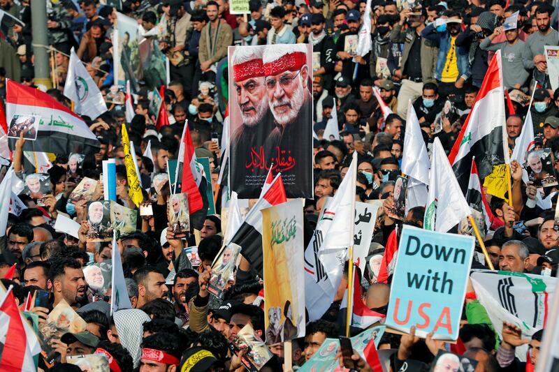 Iraqis rally in Baghdad in January 2021 to mark the first anniversary of the killing of Quds Force commander Gen Qassem Suleimani and Iraqi militia commander Abu Mahdi Al Muhandis in a US drone attack. Reuters