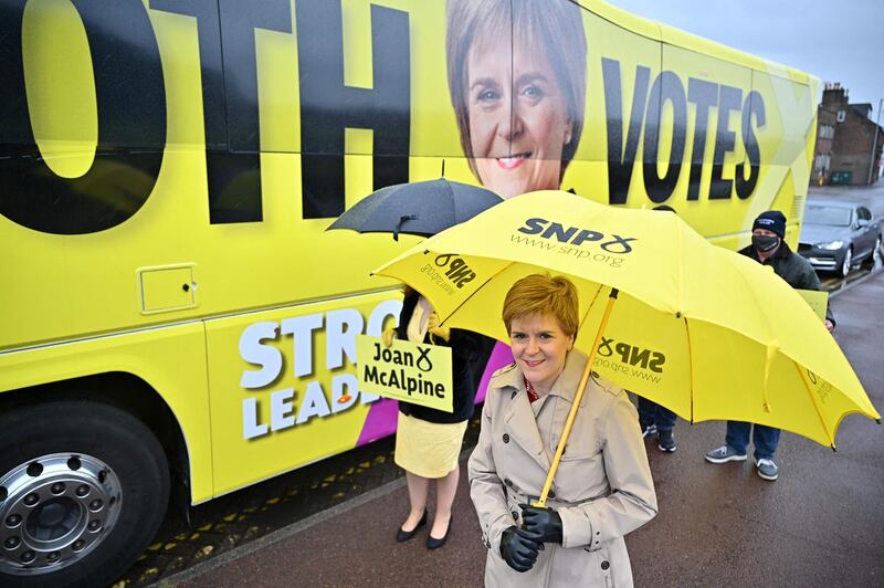 Scotland's First Minister and leader of the Scottish National Party, Nicola Sturgeon passes the SNP campaign bus as she campaigns in Midsteeple Quarter in Dumfrieshire. AFP