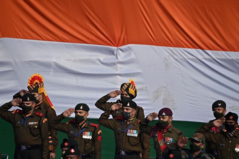 Soldiers salute during the national anthem as they stand along Rajpath during the Republic Day Parade in New Delhi. AFP