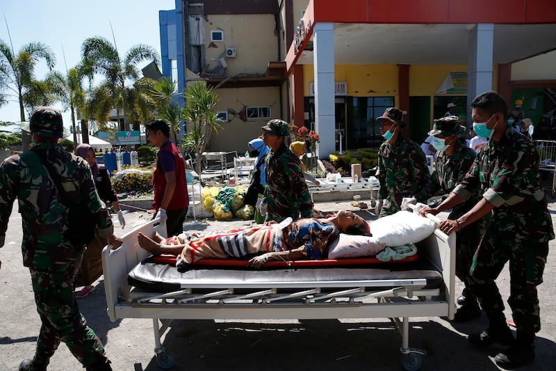 Indonesian soldiers help a hospital patient.  EPA