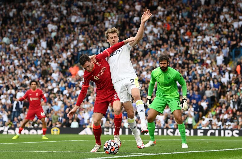 Liverpool's Andrew Robertson holds off the challenge of Leeds attacker Patrick Bamford. Getty