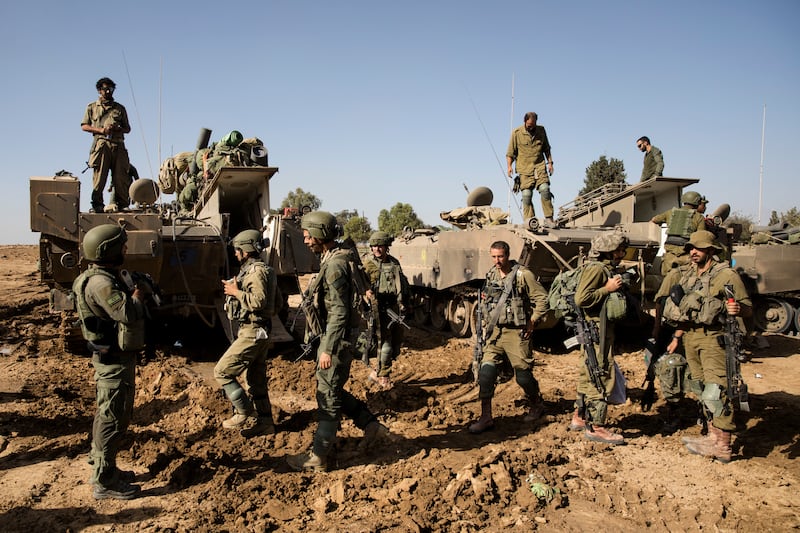 Israeli soldiers who have recently left the Gaza Strip organise their equipment. Getty Images