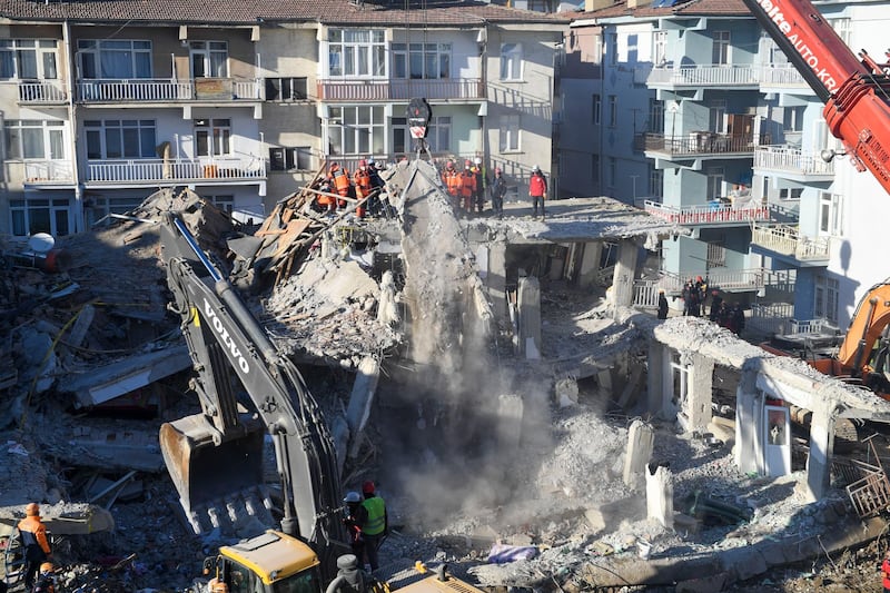 Rescue workers continue to look for people trapped under debris following a strong earthquake that destroyed several buildings on Friday, in Elazig, eastern Turkey. AP Photo