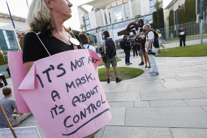 A demonstrator wears a sign reading 'it's not about mask, it's about control' in front of the chancellery after a rally against coronavirus pandemic regulations in Berlin, Germany.  EPA