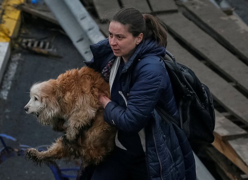 A woman carries her dog during an evacuation in the town of Irpin outside Kyiv. Reuters