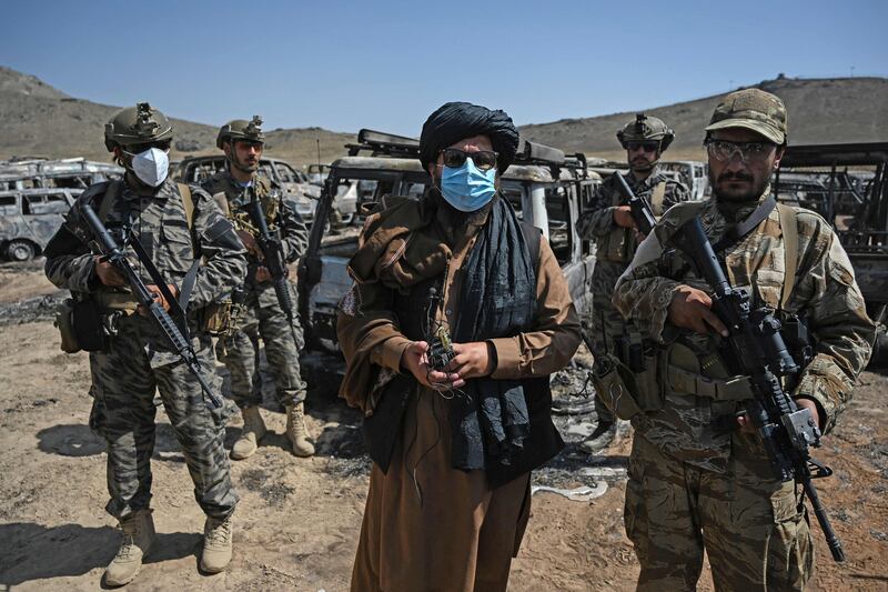 Members of the Taliban Badri 313 military unit stand beside damaged and discarded vehicles parked near the destroyed Central Intelligence Agency (CIA) base in Deh Sabz district northeast of Kabul. All photos by AFP