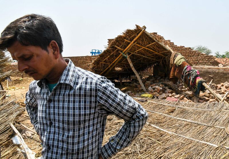 TOPSHOT - A neighbour of Rajveer Singh, 62, looks on near the debris of Singh's house that was damaged by heavy storm winds in Kheragarh on the outskirts of Agra on May 4, 2018.
Singh is suffering from serious injuries in ICU and lost his grandson and wife to the accident. A series of powerful super storms that tore through India this week have killed 143 people, as officials warned May 4 the death toll could rise with more extreme weather expected.

 / AFP PHOTO / CHANDAN KHANNA