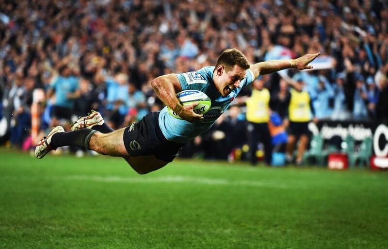 New South Wales Waratah's flyhalf Bernard Foley dives over to score the clinching try against the ACT Brumbies in their Super Rugby semi-final rugby match at Sydney on July 26, 2014. William West / AFP 