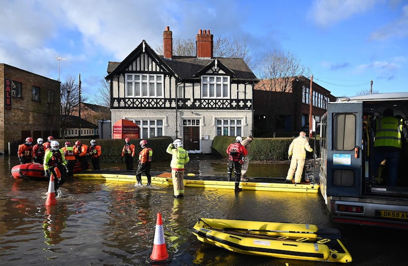 Members of the emergency services work to evacuate care home residents and workers after they became stranded by flood water in Northwich. AFP