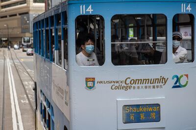 epa08582906 Passengers wear face masks as they travel on a tram in Hong Kong, China, 04 August 2020. Hong Kong announced that social-distancing measures over the coronavirus disease (COVID-19) pandemic, including a ban on gatherings of more than two people and mandatory mask-wearing in public places, will be extended by another week.  EPA/JEROME FAVRE