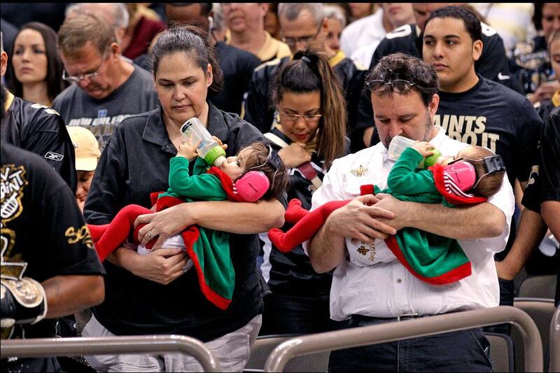 Fans pause during a moment of silence to honor 20 children and 6 adults killed Friday in a shooting rampage at Sandy Hook Elementary School in Newtown, Conn., during a game between the Saints and the Buccaneer. Bill Haber / AP Photo