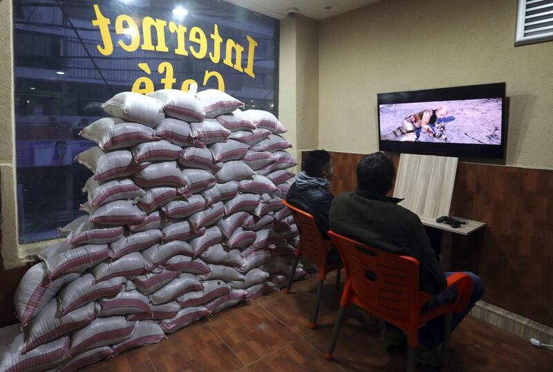 Residents play computer games at an internet cafe in the Lebanese capital of Beirut on January 28, 2014. Shop owners are taking protective measures, such as sandbagging windows, against rocket and bomb attacks that have recently rocked the city, home to the Shiite group Hizbollah. Hasan Shaaban / Reuters photo
