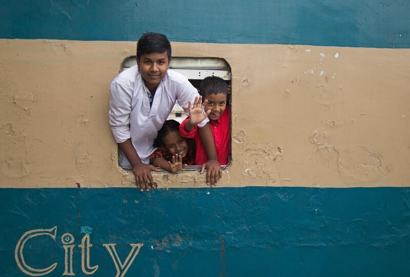 Bangladeshi children lean out the window of a train as they travel home with their family to celebrate, ahead of Eid al- Fitr festival, at the Kamalapur Railway Station in Dhaka. Monirul Alam / EPA