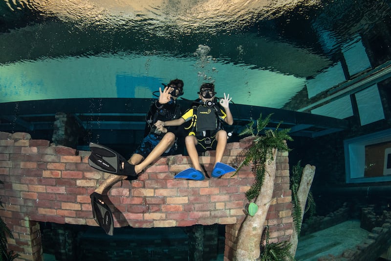 Divers get a chance to explore an underwater apartment, garage and arcade, among other things.