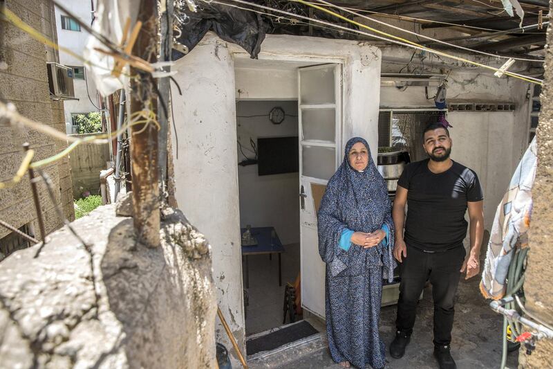 Motes Abu Khader,26, and his mother Nada.47,outside  their hime in the Aida refugee camp near the Palestinian city of Bethlehem on June 23,2019. Eight family members live in the home . Photo by Heidi Levine for The National